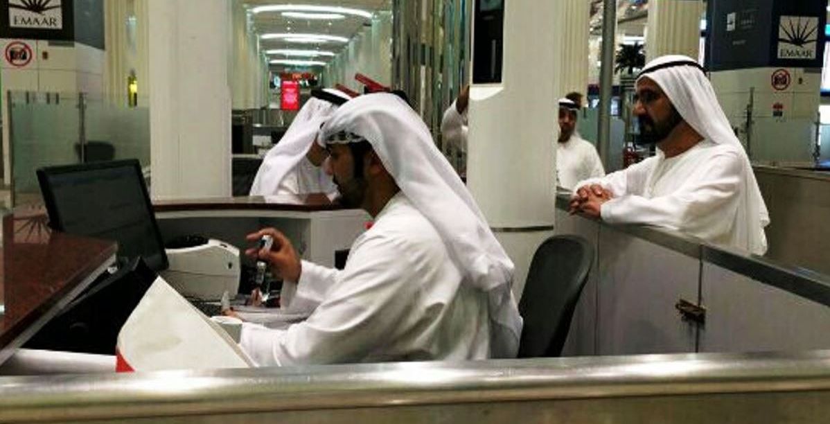 محمد بن راشد يقف خلف مأمور الجوازات (تويتر/@GDRFADUBAI)