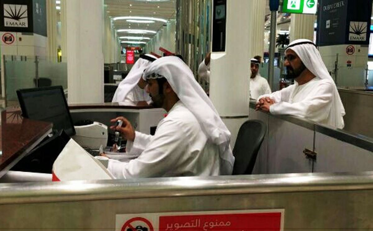 محمد بن راشد يقف خلف مأمور الجوازات (تويتر/@GDRFADUBAI)