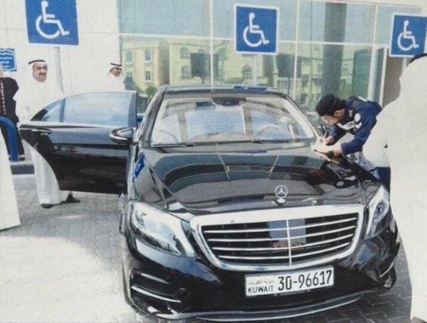 رجل امن كويتي يحرر مخالفة لسيارة وزير التجارة